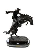 After Frederic S. Remington (American, 1861–1909), “Bronco Buster” a dark patinated bronze depicting