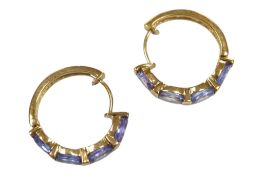 A recent pair of 9ct gold and four stone oval cut tanzanite set half hoop earrings, approx. 20mm,