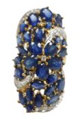 A recent 9ct gold, sapphire and diamond cluster set dress ring, of saddle form, size N, gross weight