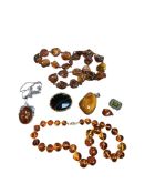 A collection of natural amber jewellery to include two pendants and a bead necklace, together with