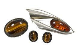 A white metal and Tiger's eye quartz demi-parure, brooch 38mm and a stylish white metal and amber