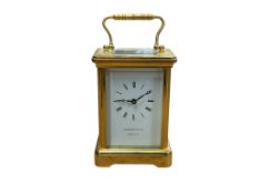 A small lacquered brass carriage timepiece retailed by Garrard and Co, with key, height 12cm.