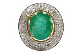 A recent 9ct gold and single stone oval cut emerald set ring with three row diamond chip set border,