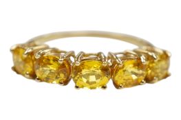 A recent 9ct gold and five stone oval cut yellow sapphire set half hoop ring, size N, gross weight