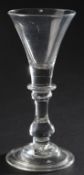A George II baluster wine glass, circa 1720,with trumpet bowl over a basal blade knop, the