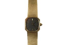 A lady's Omega 9ct gold Omega manual wind wrist watch, with baton numerals, on an integral 9ct