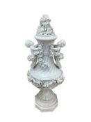 A German floral encrusted 'cherub' vase and cover, height 41cm.