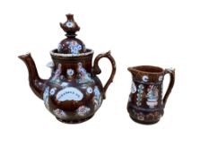 A Measham bargeware “Remember Me” teapot, height 33cm and a smaller “Forget me Not” jug (2)