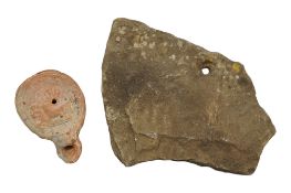 A Roman terracotta 'erotic' oil lamp and a Roman 'ragstone' roof tile, Kentish, approximately 21 x