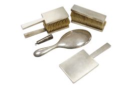A mid 20th century engine turned silver five piece dressing table set, London, 1949, together with a