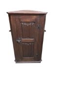 An oak linen fold hanging corner cupboard, width 46cm, depth 26cm, height 74cm