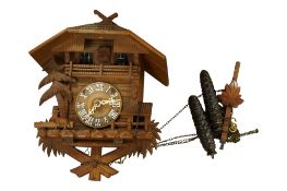 A Black Forest Cuckoo clock, with pinecone weights and pendulum, height 30cm.