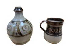 Two pieces of Winchcombe pottery comprising a jug dated 1976 and a lamp base, each with impressed
