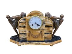 An Art Deco Sienna marble mantel clock surmounted with two gilt metal figures, striking on a bell,