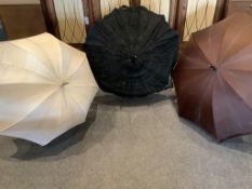 Two early 20th century umbrellas and a lace parasol unused for many years. The cream silk