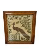 A late 19th century wool worked panel of a Peacock standing on plinth. Wool work within a Birds