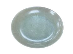 A Chinese bowenite jade saucer dish, on a circular foot, 12.3cm in diameter