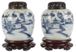 A pair of Chinese blue and white jars, 18th century, with pierced wood stands and covers, height