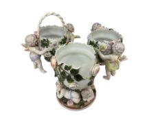 A Sitzendorf floral encrusted cherub and egg porcelain centrepiece, height 16cm, and a pair of
