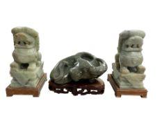A pair of large Chinese jade lion-dogs and a buffalo all on wood stands, lion dogs 25cm high