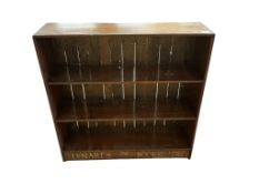 An early 20th century pine open bookcase with painted inscription for 'Lenards The Bookseller',