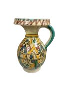 A Moroccan painted pottery jug, decorated with geometric motifs, 18cm high.