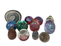 Twelve decorative glass paperweights by Caithness, largest 13cm tall.