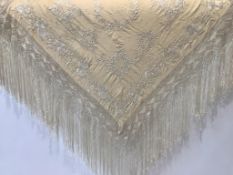 A Chinese cream silk shawl, with white silk floral embroidery finished with a deep crochet silk
