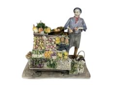 Longo Cerva, The Greengrocer, a painted ceramic figure group, circa 1970, 25cm high.