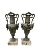 A pair of spelter twin handled urns raised on marble bases, 37cm high