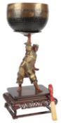 A large Japanese bronze figure of Benkei holding aloft a bell, in Miyao style, Meiji period, the