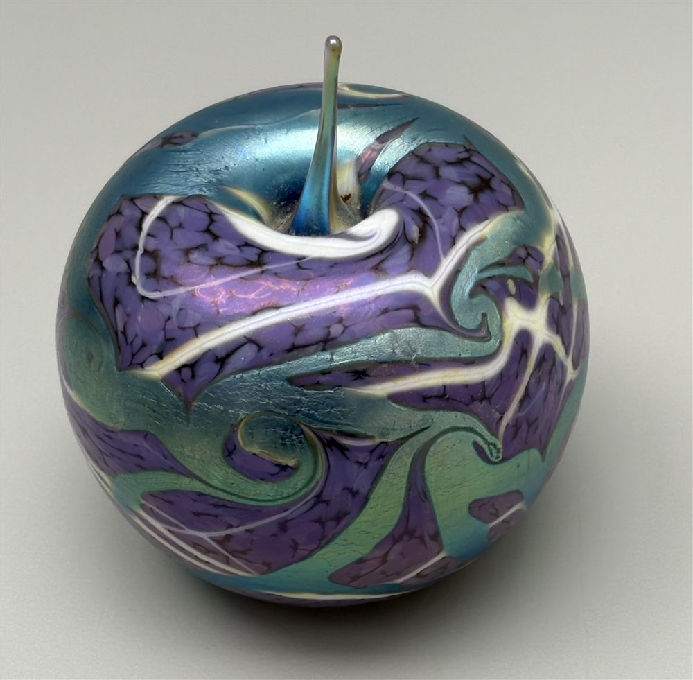 OKRA- AN IRIDESCENT ART GLASS APPLE PAPERWEIGHT decorated in purple and ...