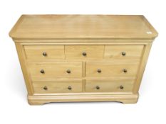A contemporary light teak bank of drawers with three short over two rows of two drawers all with