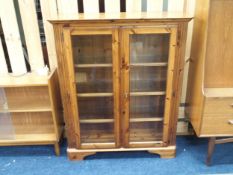 A 20th century pine two door glazed bookcase on plinth base, 120cm high x 100cm wide x 32cm deep