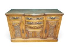 A late Victorian oak sideboard with three central drawers over single carved cabinet door flanked by