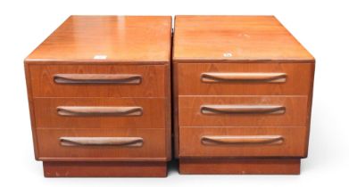 A pair of mid 20th century teak G Plan "Fresco" three drawer bedside chests with moulded handles