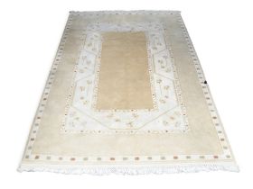An Ivory ground Turkish rug with plain beige rectangular panel centre within geometric floral
