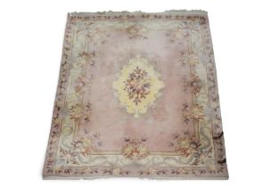 A large deep pile pink ground Oriental style rug with cream floral decorated central medallion