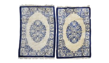 A pair of cream ground deep pile Oriental style rugs with blue scrolled floral/foliate decorated