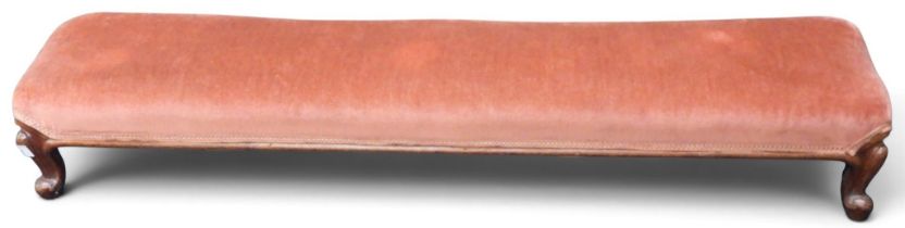 A late 19th century walnut framed bolster stool with pink upholstery on serpentine supports, 18cm