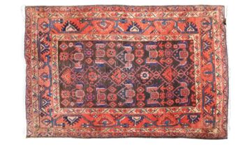 A dark ground Hamadan rug with geometric patterned ground within multicoloured geometric patterned