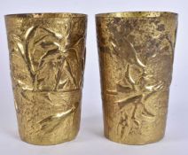 A PAIR OF ANTIQUE GILDED REPOUSSE BEAKERS decorated with foliage. 11 cm x 7.5 cm.