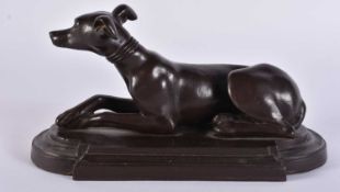A VICTORIAN BRONZE FIGURE OF A RECUMBENT GREYHOUND. 17 cm x 10 cm.