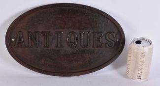 A VINTAGE CAST IRON ANTIQUES SIGN. 34 cm x 21 cm.