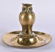 AN EDWARDIAN BRASS GLASS EYED OWL DESK STAND. 11 cm x 11 cm.