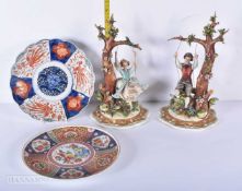 A pair of Capodimonte ceramic figures together with a Japanese Imari plate and a Chinese plate