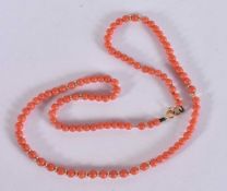 A 9CT GOLD AND CORAL NECKLACE. 7.9 grams. 42 cm long.