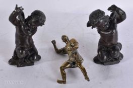 A 19TH CENTURY GRAND TOUR BRONZE FIGURE OF A ROMAN SOLDIER together with a pair of putti. 14.5 cm