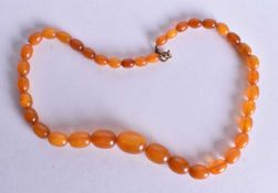 AN AMBER NECKLACE. 21 grams. 38 cm long, largest bead 2 cm wide.