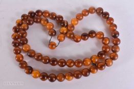 AN AMBER STYLE NECKLACE. 72 cm long, largest bead 1.75 cm wide.